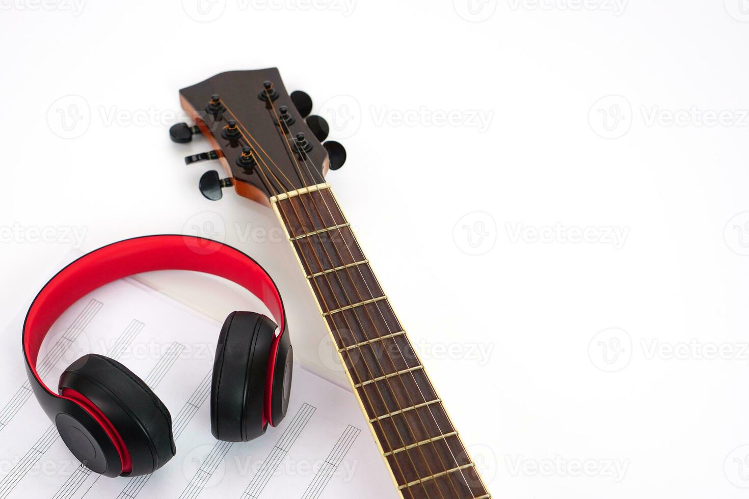 guitarra acústica, auriculares y notas musicales sobre un fondo blanco. concepto de amor y música. foto