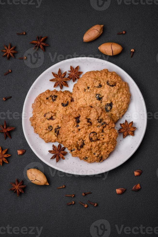 Delicious baked oatmeal raisin cookies on a dark concrete background photo