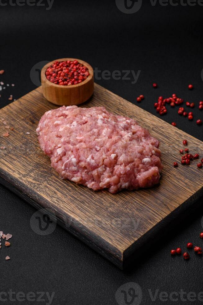 Raw minced beef, pork or chicken meat with salt, spices and herbs photo