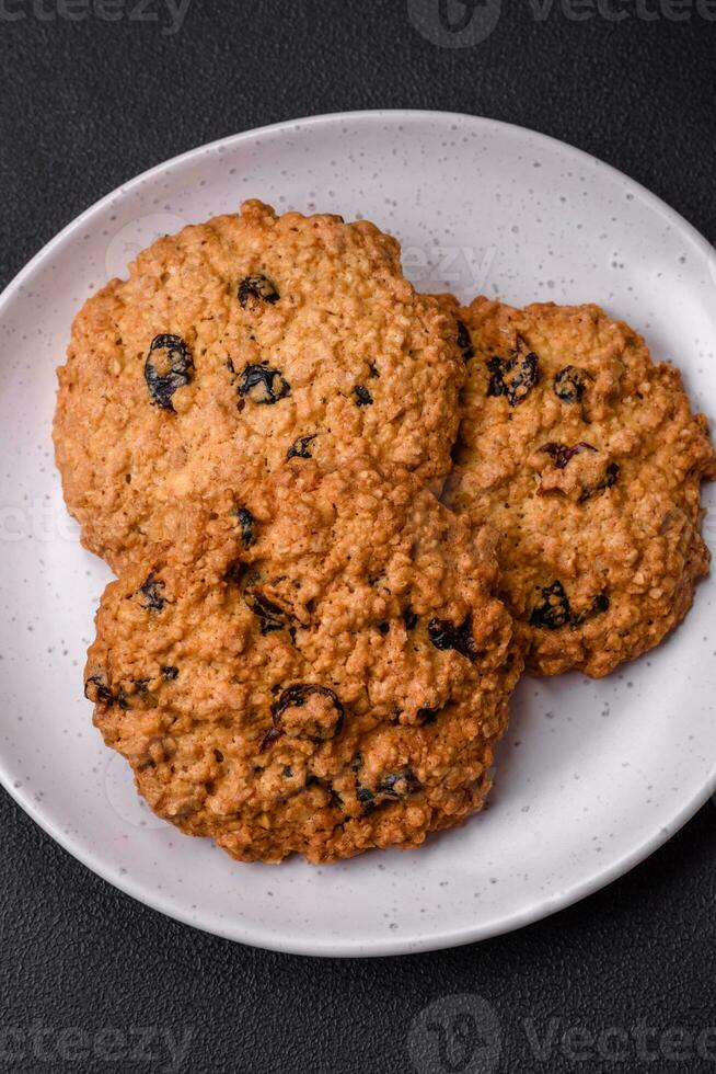 Delicious baked oatmeal raisin cookies on a dark concrete background photo