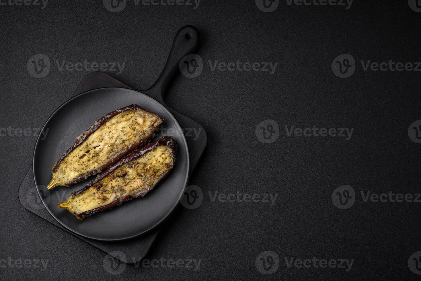 Delicious eggplant cut into two halves baked with salt, spices and herbs photo