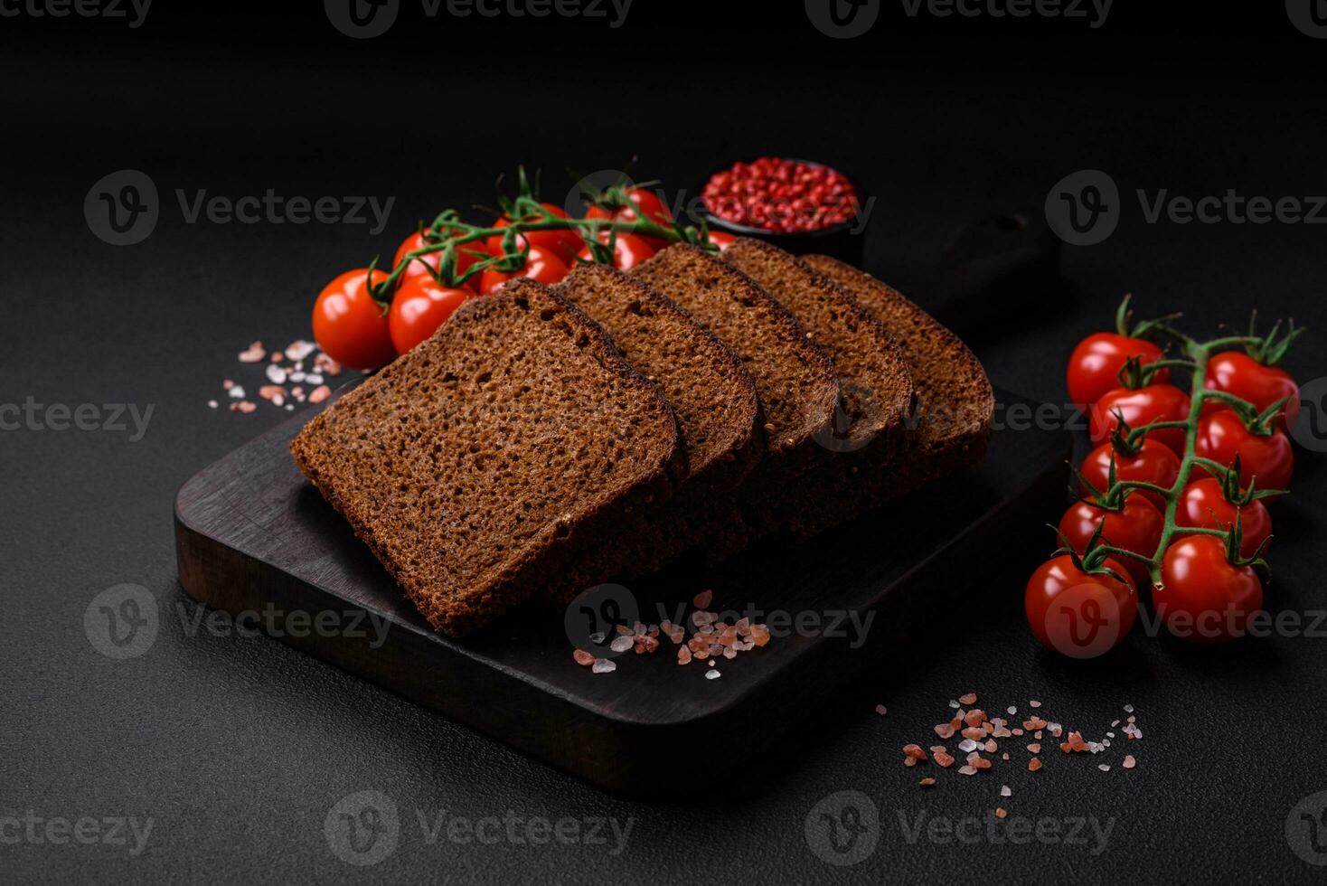 Delicious fresh brown bread with grains and seeds sliced on a wooden cutting board photo