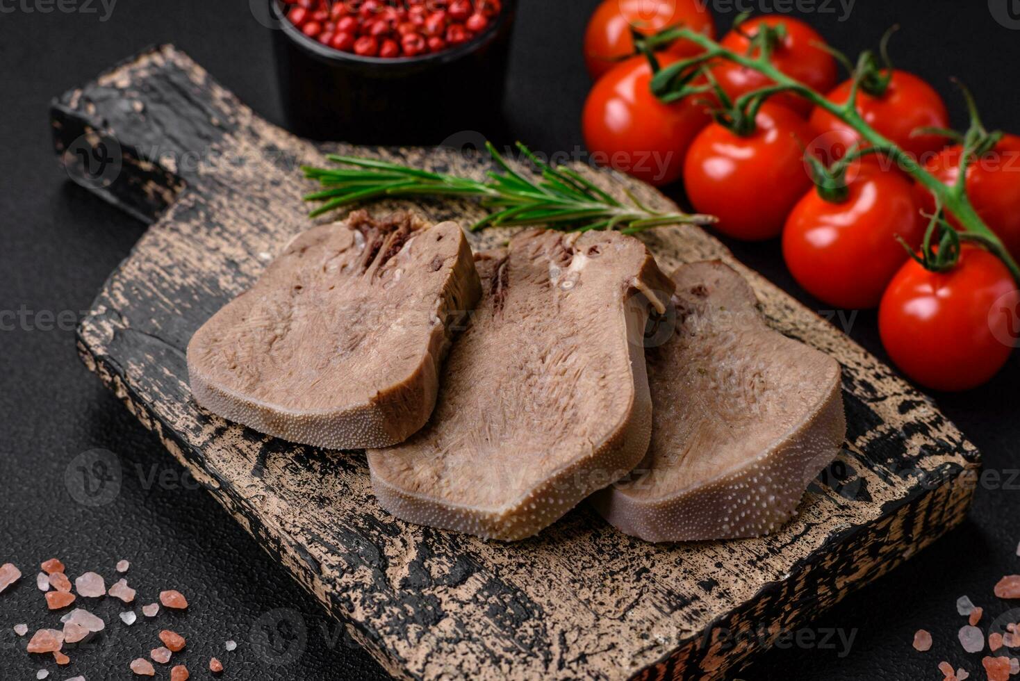Delicious boiled beef tongue sliced with vegetables and spices photo