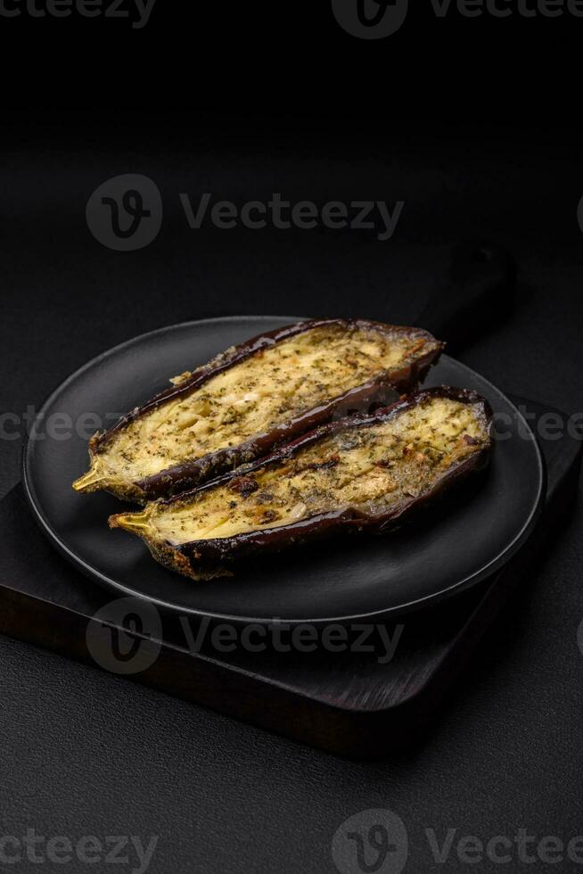 Delicious eggplant cut into two halves baked with salt, spices and herbs photo