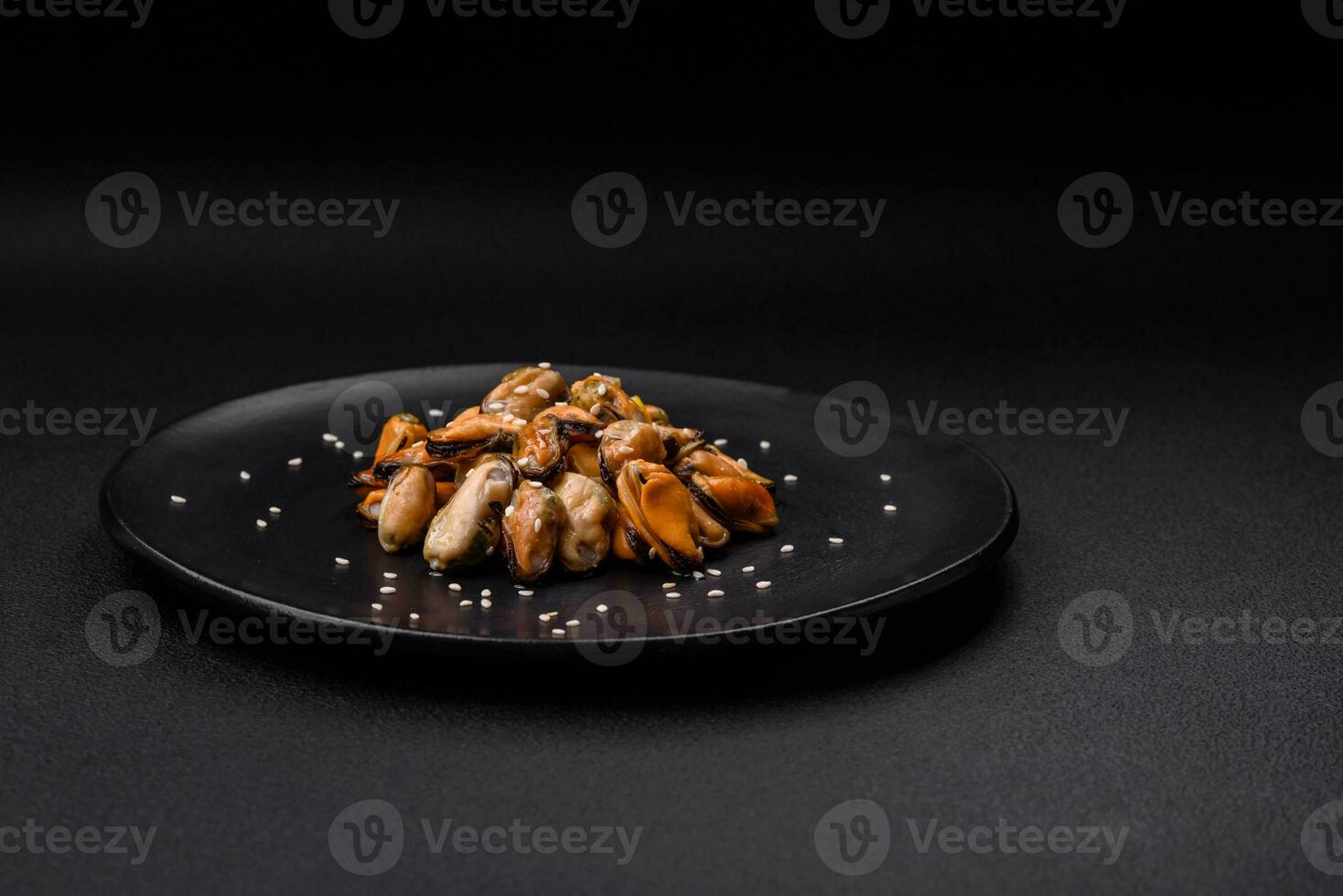 Delicious marinated mussels with spices and herbs on a ceramic plate photo