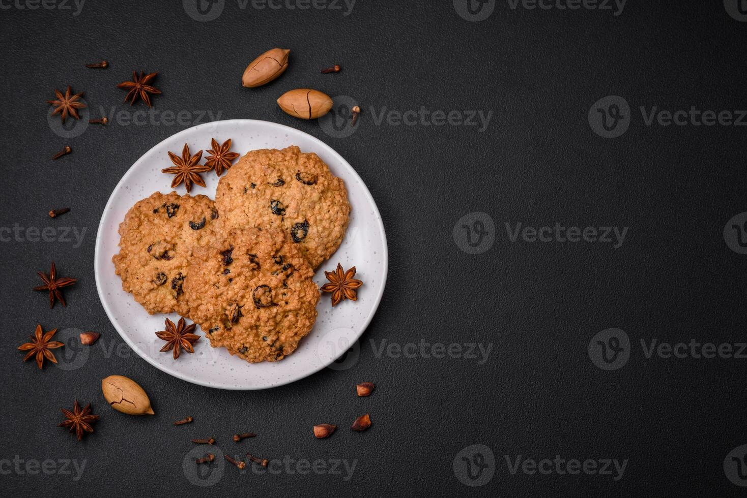 Delicious baked oatmeal raisin cookies on a dark concrete background photo