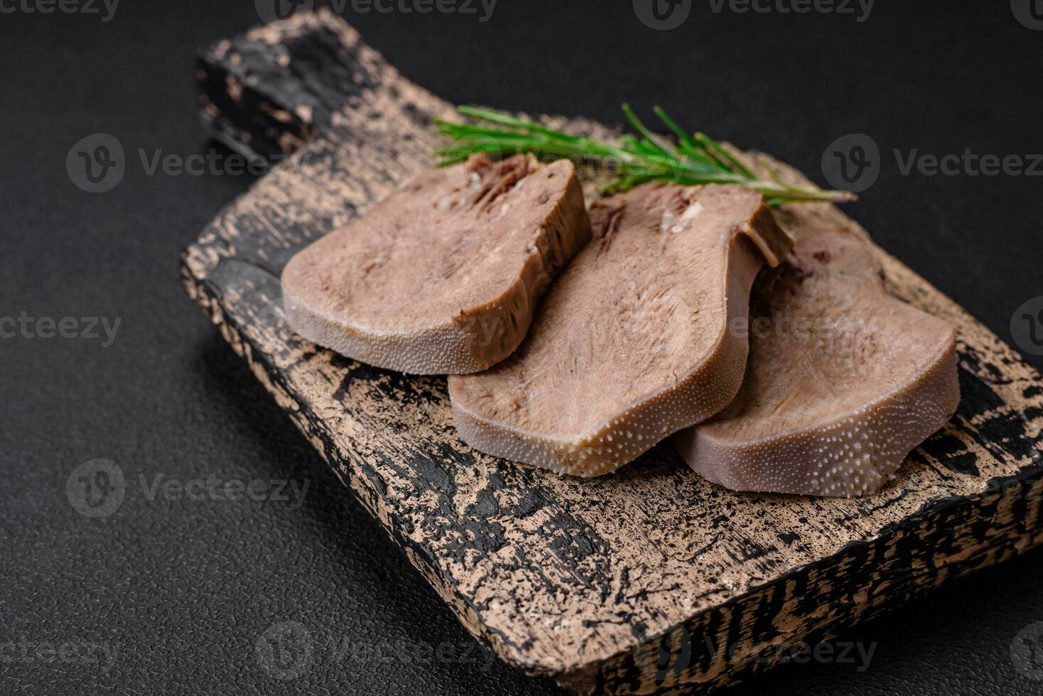 Delicious boiled beef tongue sliced with vegetables and spices photo