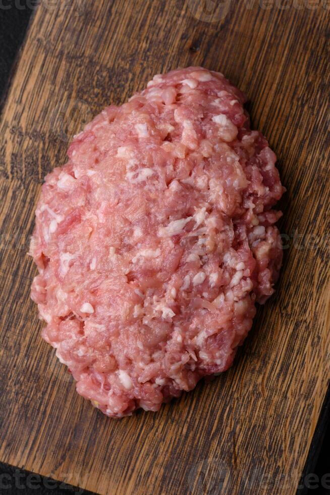 Raw minced beef, pork or chicken meat with salt, spices and herbs photo