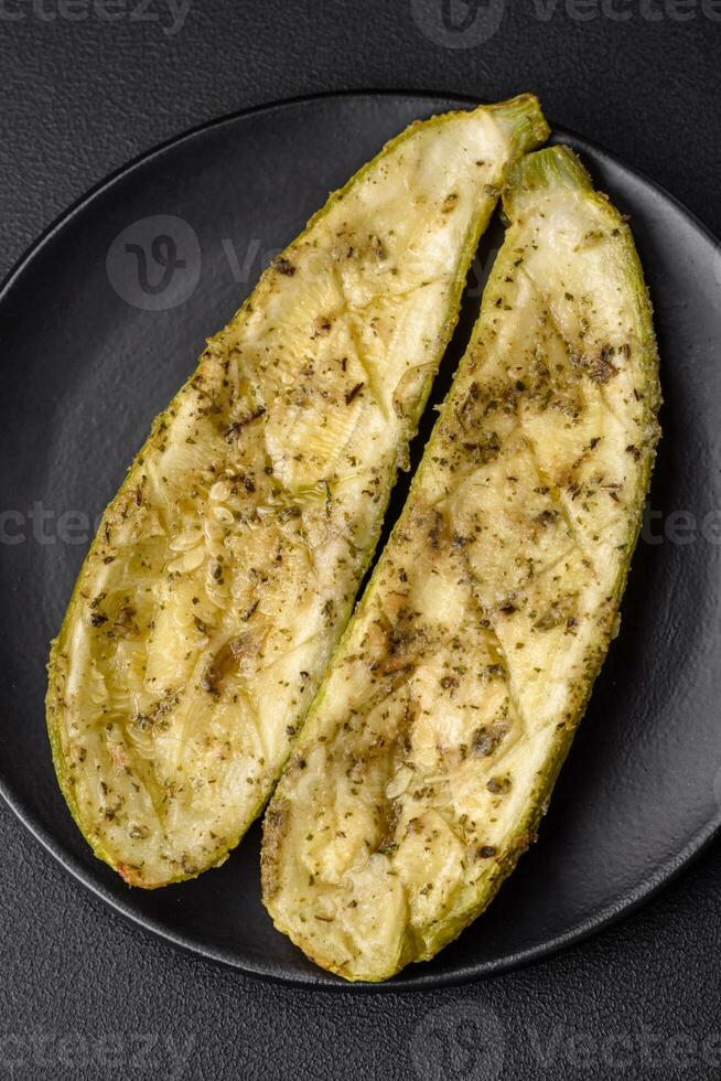 Delicious zucchini cut into two halves baked with salt, spices and herbs photo