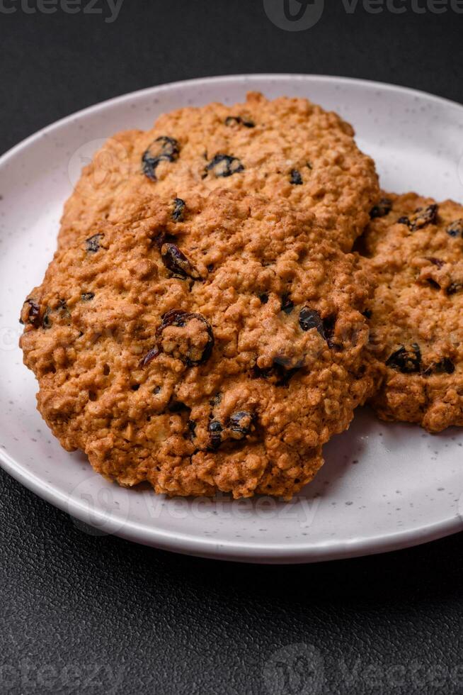 Delicious baked oatmeal raisin cookies on a dark concrete background photo