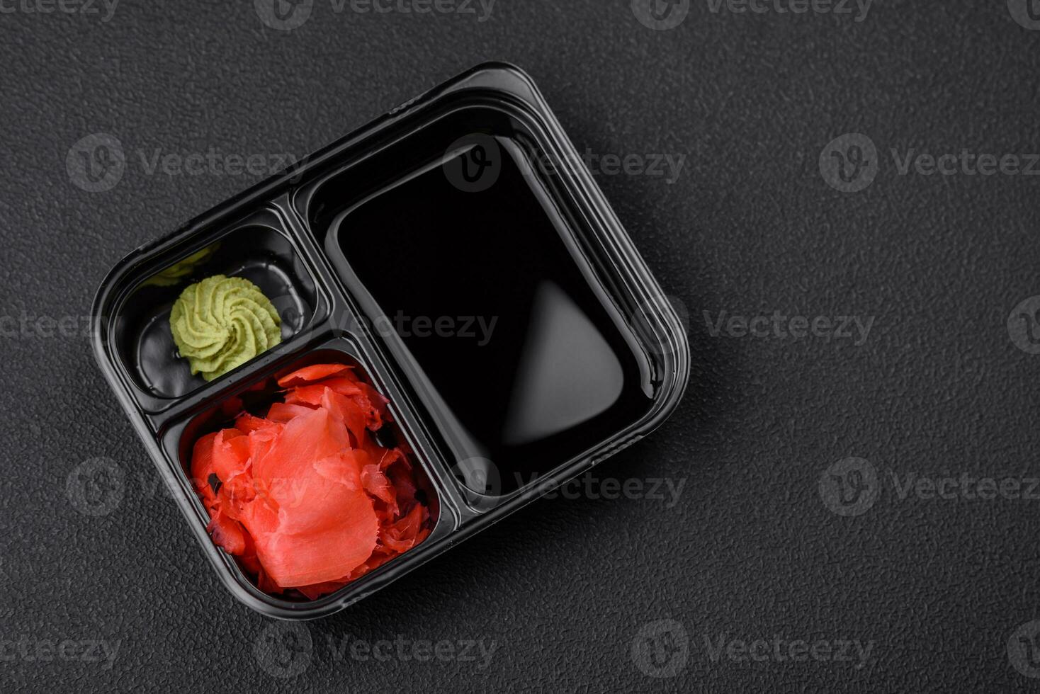 Pickled ginger, soy sauce and wasabi in portioned plastic containers photo