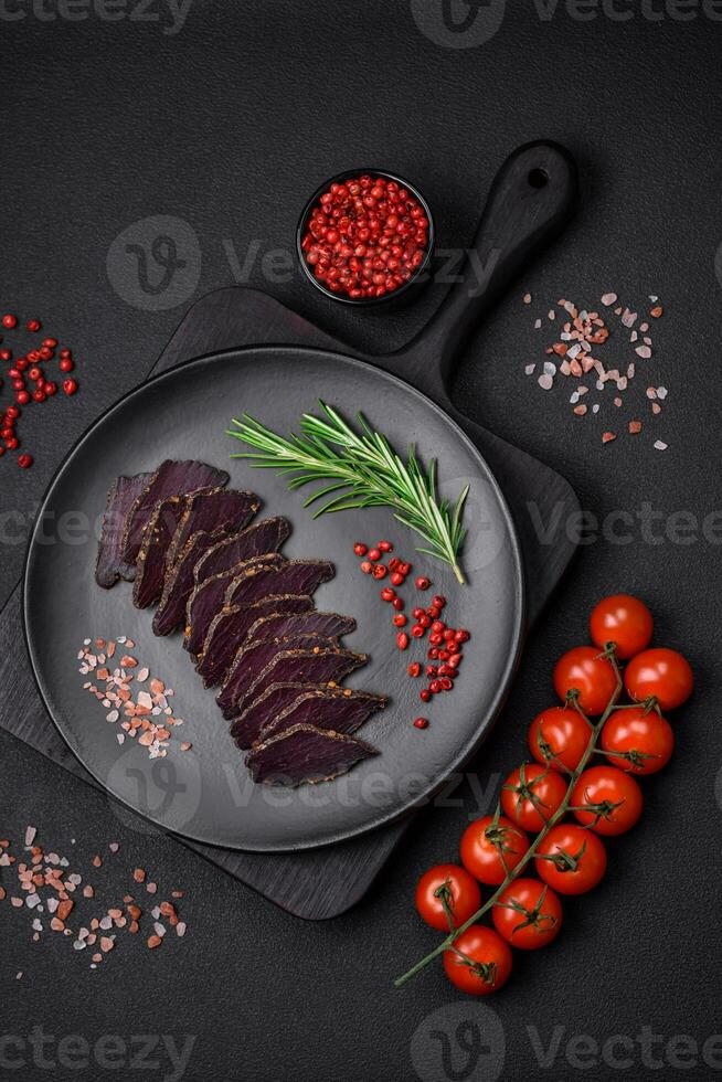 Delicious dried smoked beef or horse meat jerky with spices and salt photo