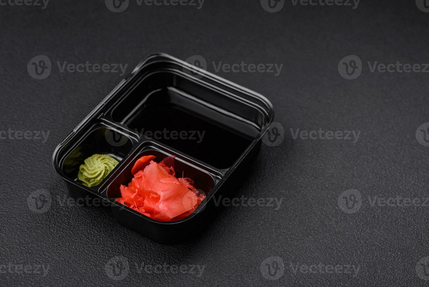 Pickled ginger, soy sauce and wasabi in portioned plastic containers photo
