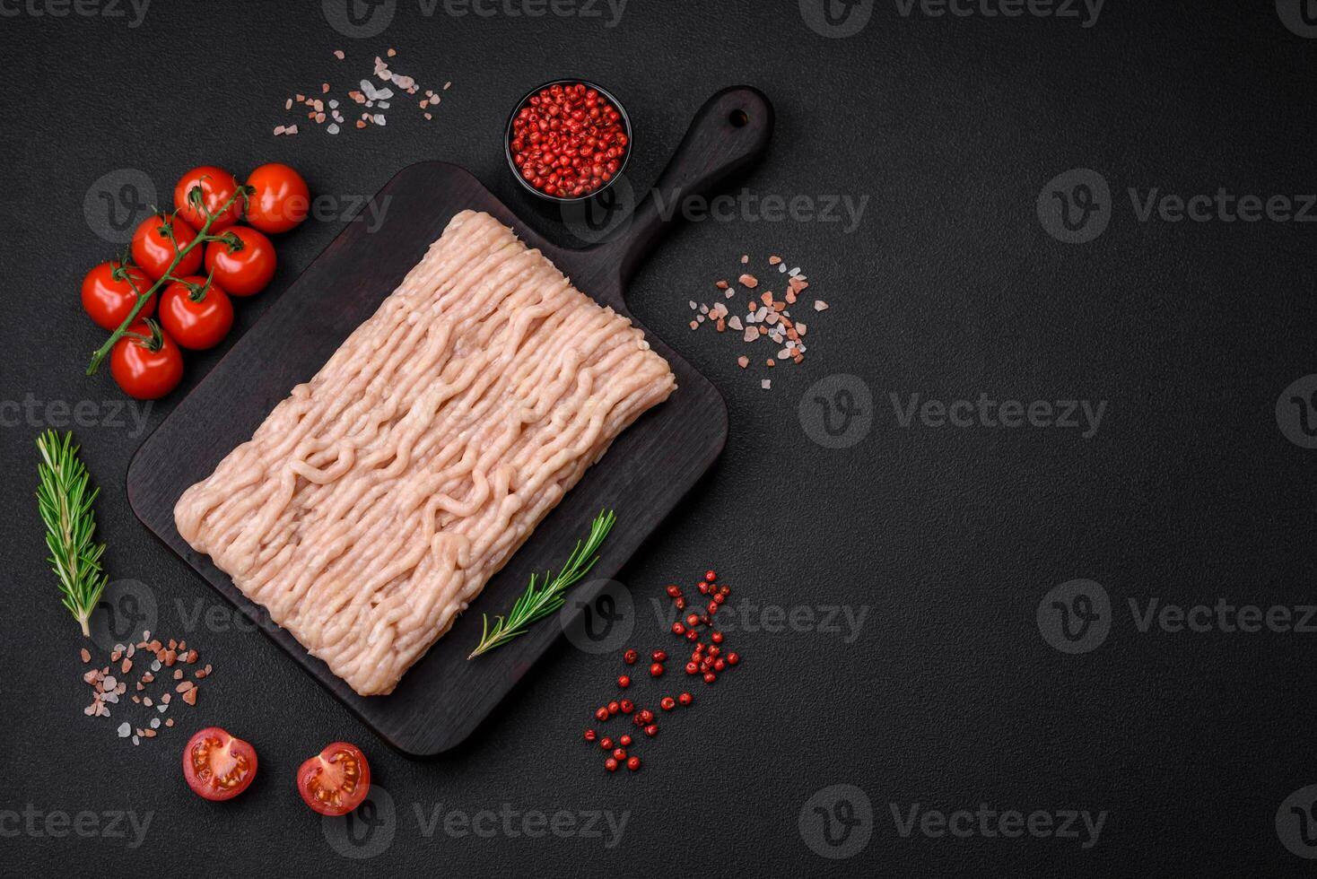 Fresh minced chicken with salt, spices and herbs on a wooden cutting board photo