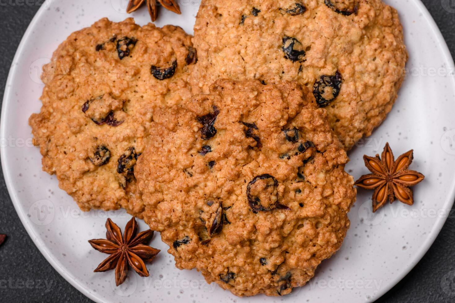 Delicious baked oatmeal raisin cookies on a dark concrete background photo