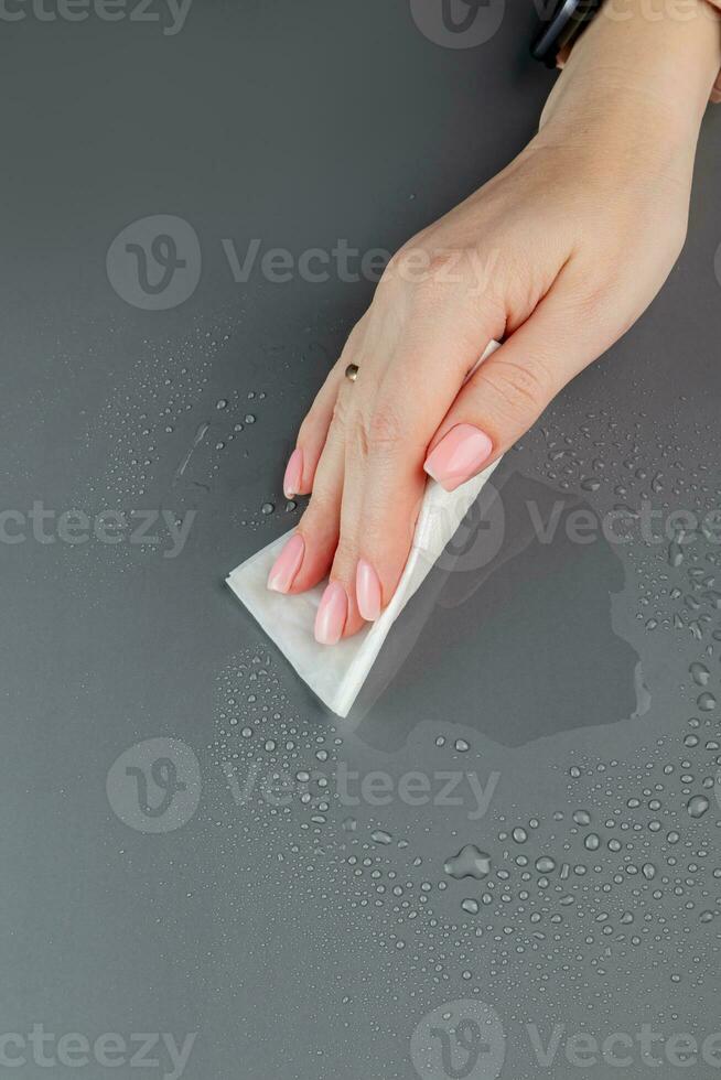 mujer mano limpieza el mesa superficie con mojado toallitas foto