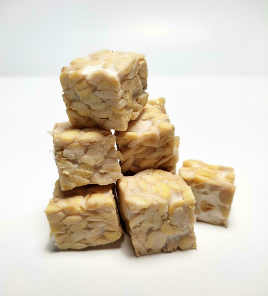 Pile of raw tempeh, dice cutting, On White Background. photo
