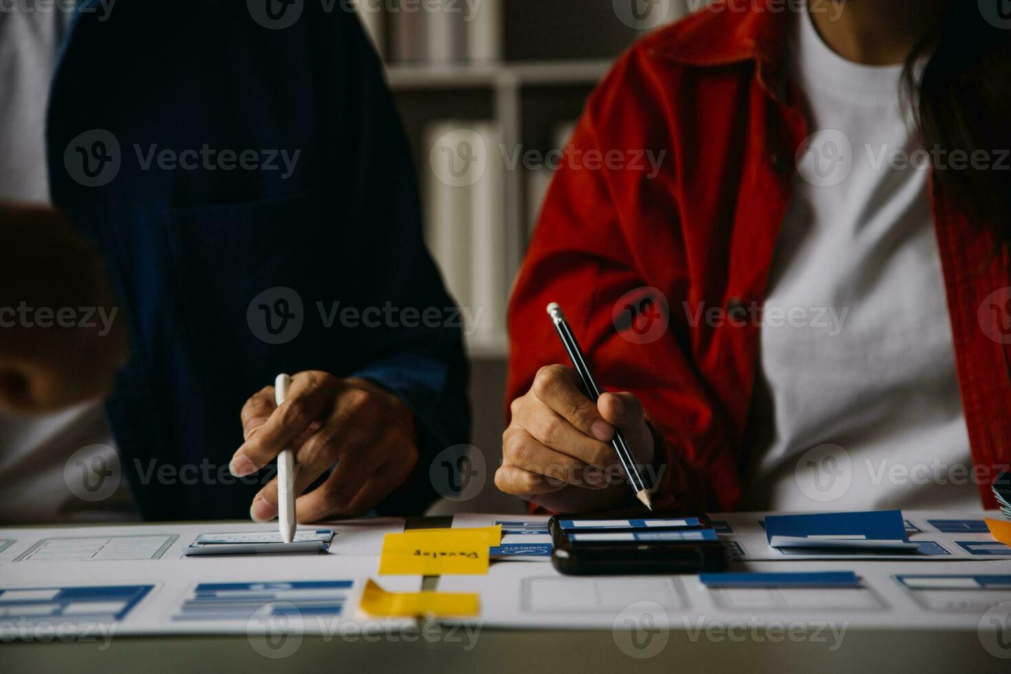 Close up ux developer and ui designer brainstorming about mobile app interface wireframe design on table with customer breif and color code at modern office.Creative digital development agency photo
