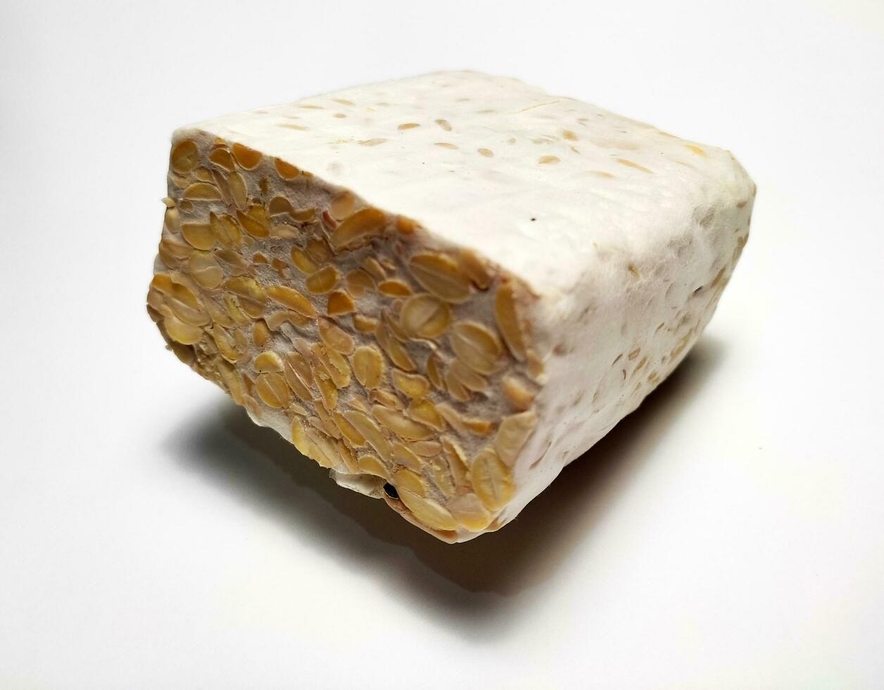 crudo tempeh o temperatura, indonesio tradicional alimento, hecho desde fermentado soja, en blanco antecedentes. foto