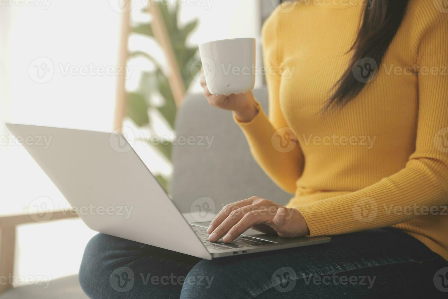 Young adult happy smiling Hispanic Asian student wearing headphones talking on online chat meeting using laptop in university campus or at virtual office. College female student learning remotely. photo