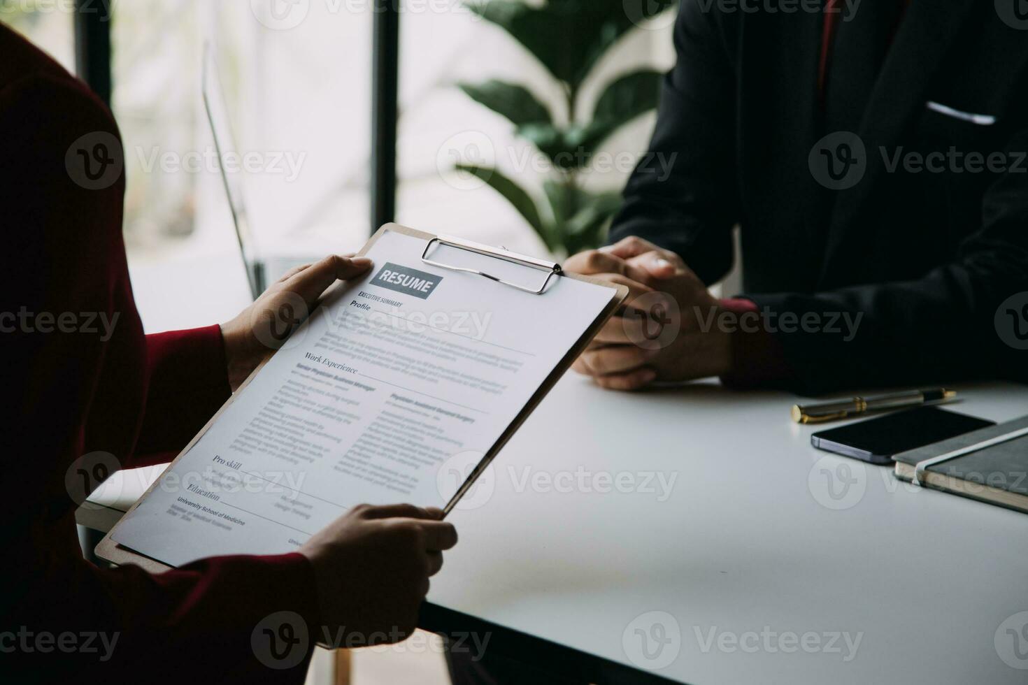 Close up view of job interview in office, focus on resume writing tips, employer reviewing good cv of prepared skilled applicant, recruiter considering application, hr manager making hiring decision photo