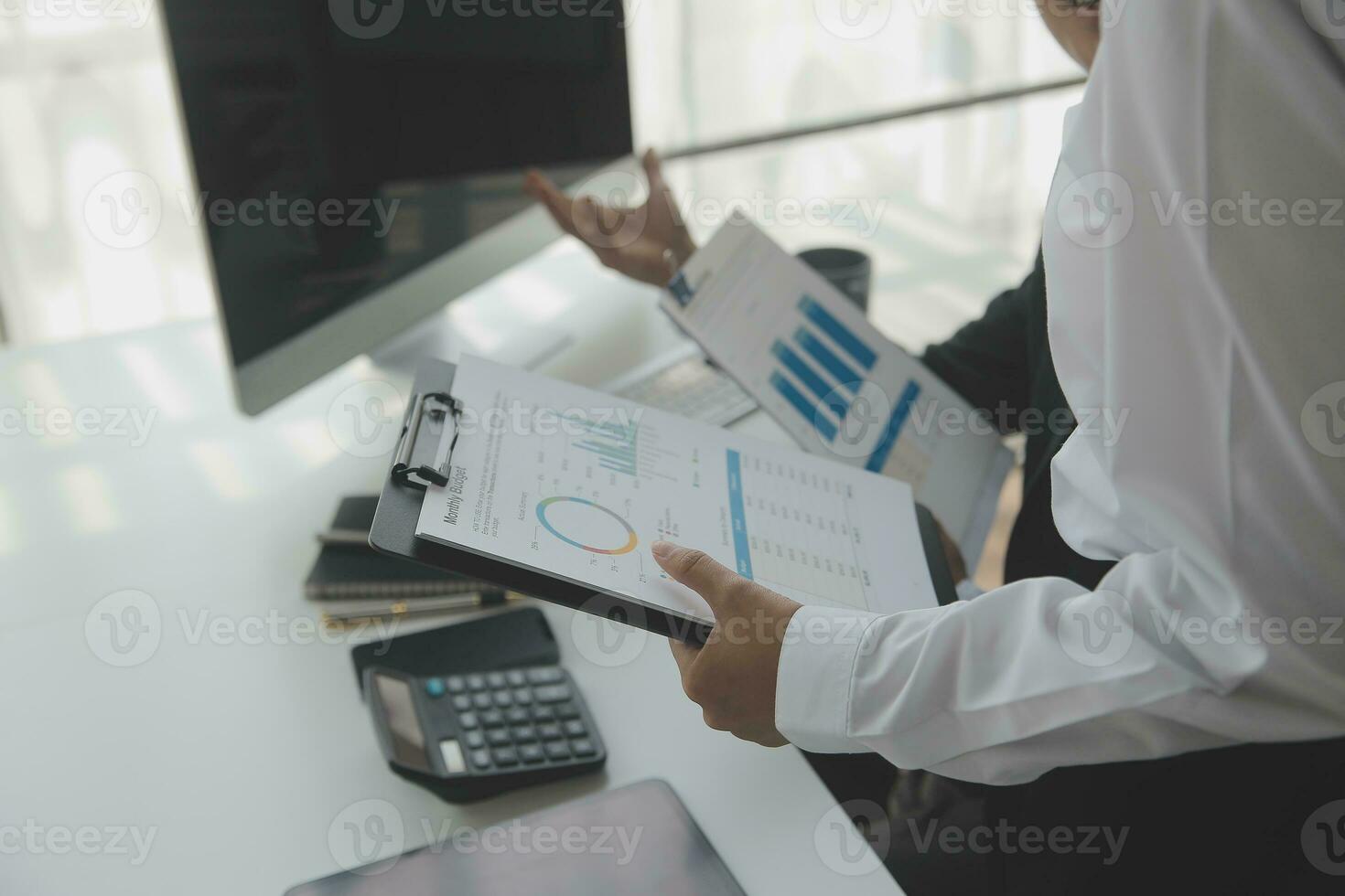 Group of confident business people point to graphs and charts to analyze market data, balance sheet, account, net profit to plan new sales strategies to increase production capacity. photo