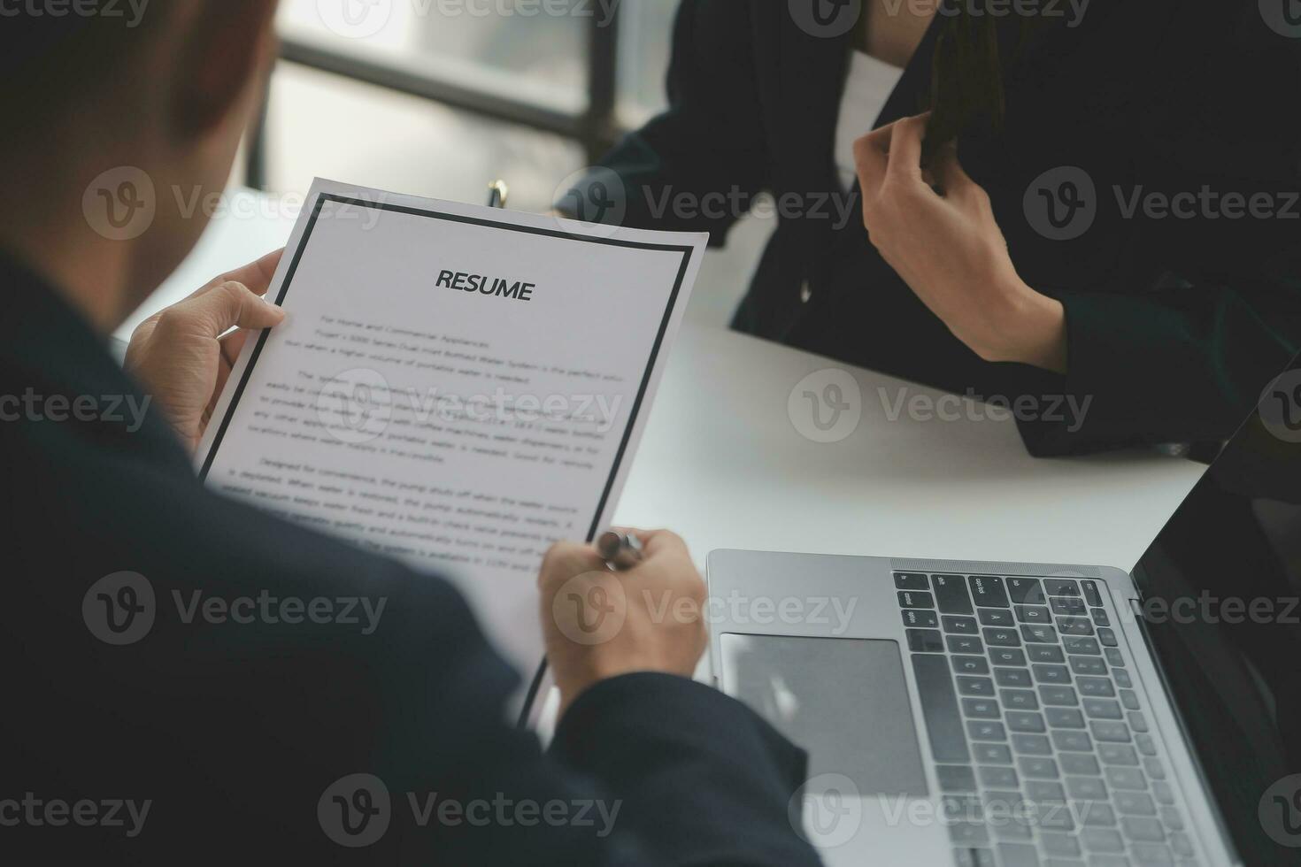 Close up view of job interview in office, focus on resume writing tips, employer reviewing good cv of prepared skilled applicant, recruiter considering application, hr manager making hiring decision photo