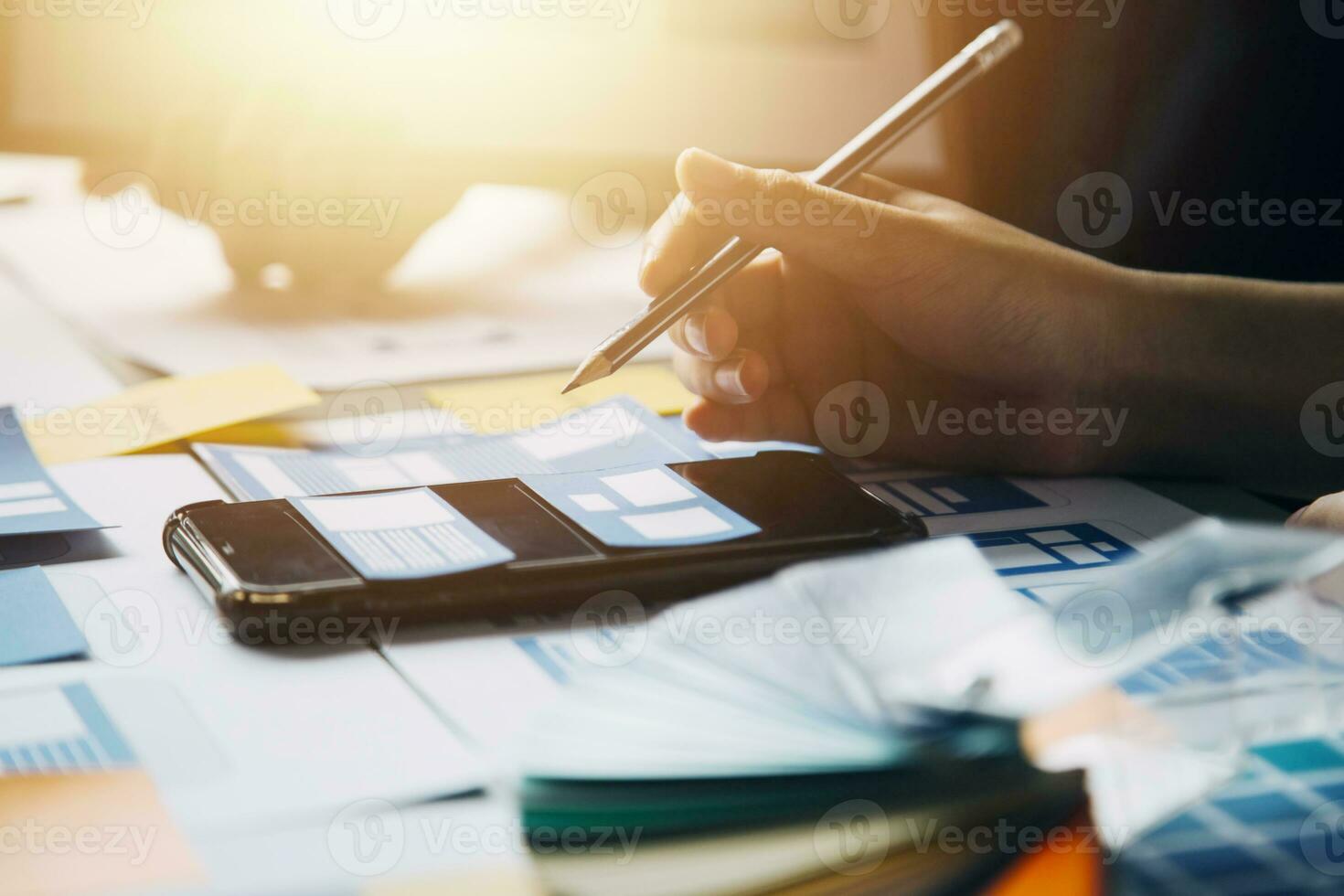 Close up ux developer and ui designer brainstorming about mobile app interface wireframe design on table with customer breif and color code at modern office.Creative digital development agency photo