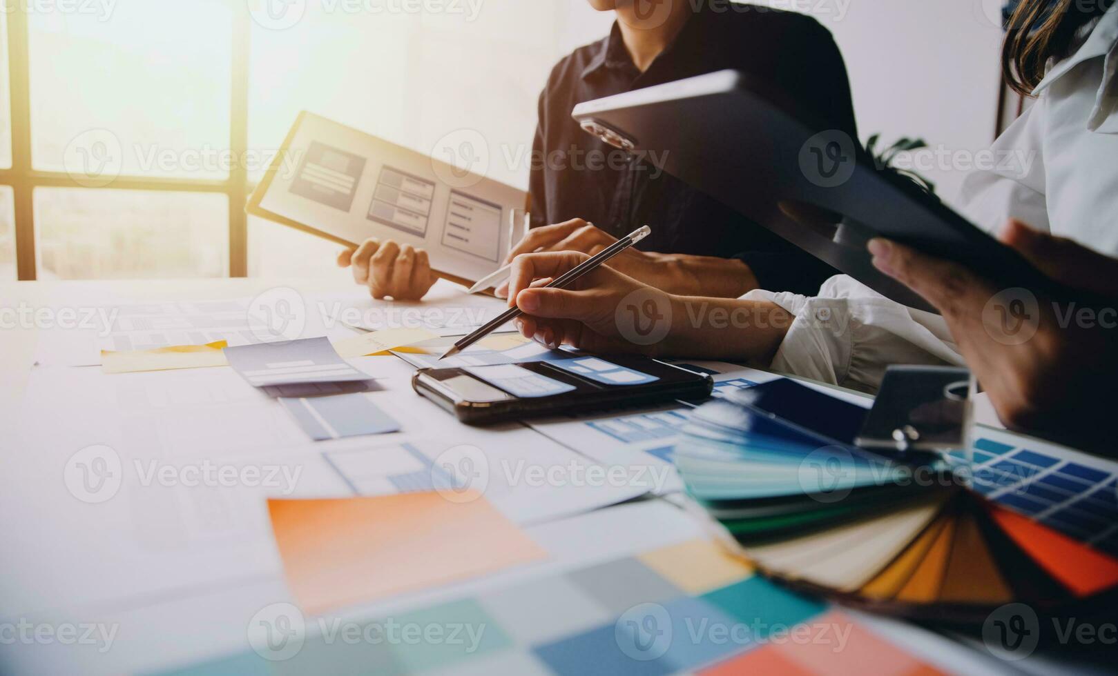 Close up ux developer and ui designer brainstorming about mobile app interface wireframe design on table with customer breif and color code at modern office.Creative digital development agency photo