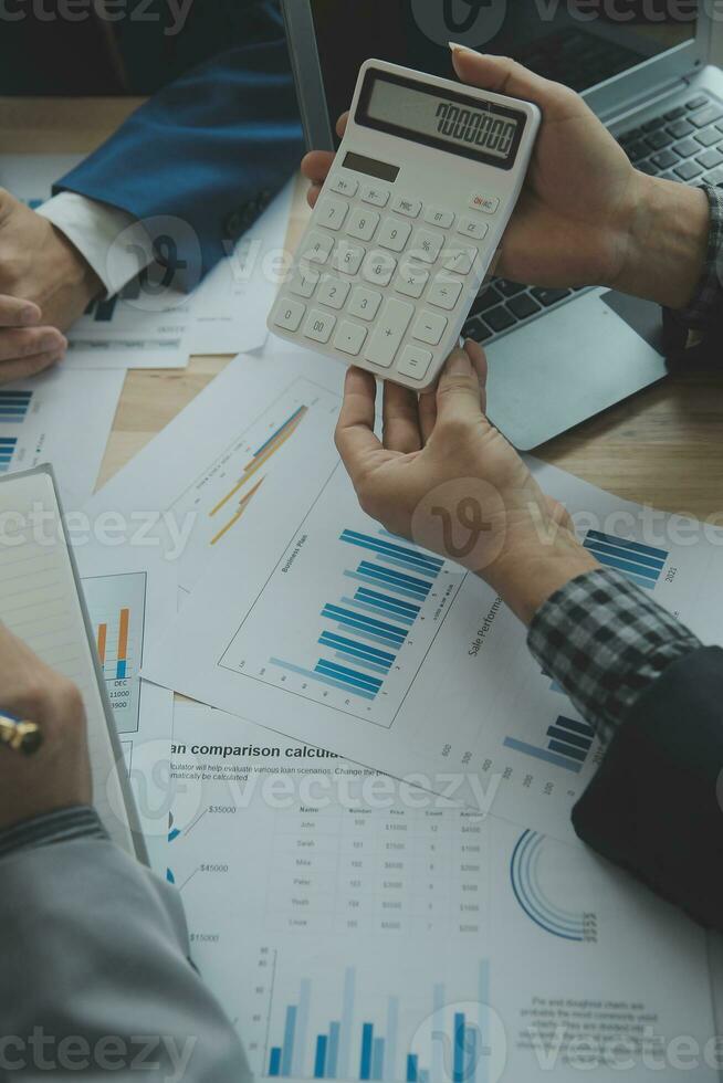 Group of confident business people point to graphs and charts to analyze market data, balance sheet, account, net profit to plan new sales strategies to increase production capacity. photo