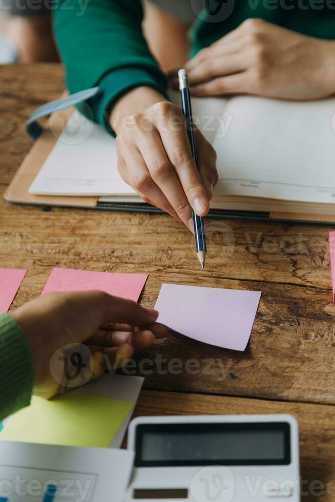 Brainstorming Collaboration and successful partnership analysis by Young business Asian people working in an office workspace photo