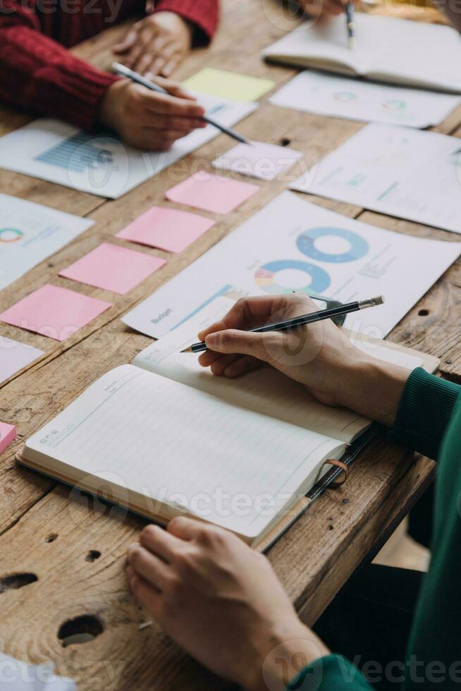 Brainstorming Collaboration and successful partnership analysis by Young business Asian people working in an office workspace photo