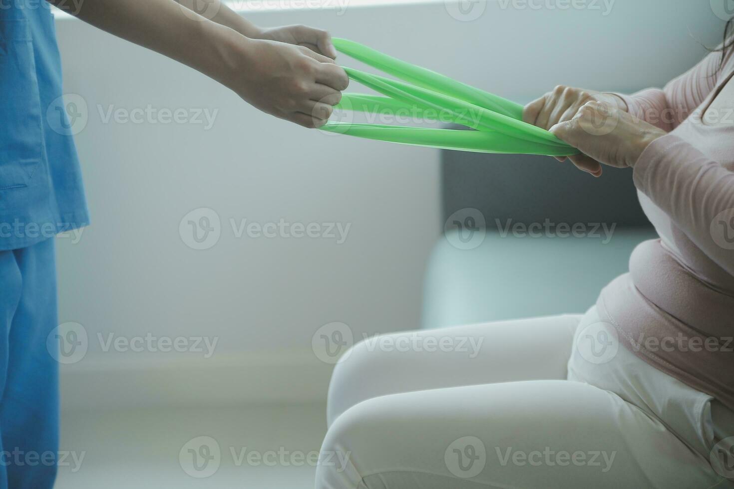 young asian physical therapist working with senior woman on walking with a walker photo