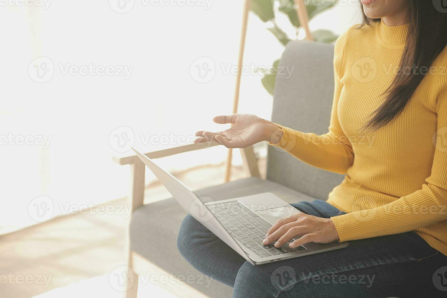 Young adult happy smiling Hispanic Asian student wearing headphones talking on online chat meeting using laptop in university campus or at virtual office. College female student learning remotely. photo