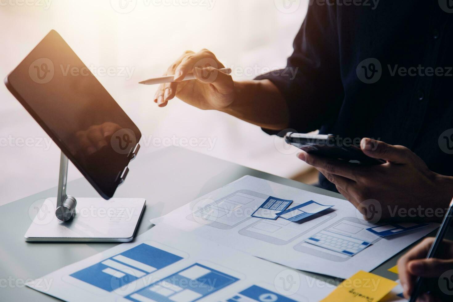 Close up ux developer and ui designer brainstorming about mobile app interface wireframe design on table with customer breif and color code at modern office.Creative digital development agency photo