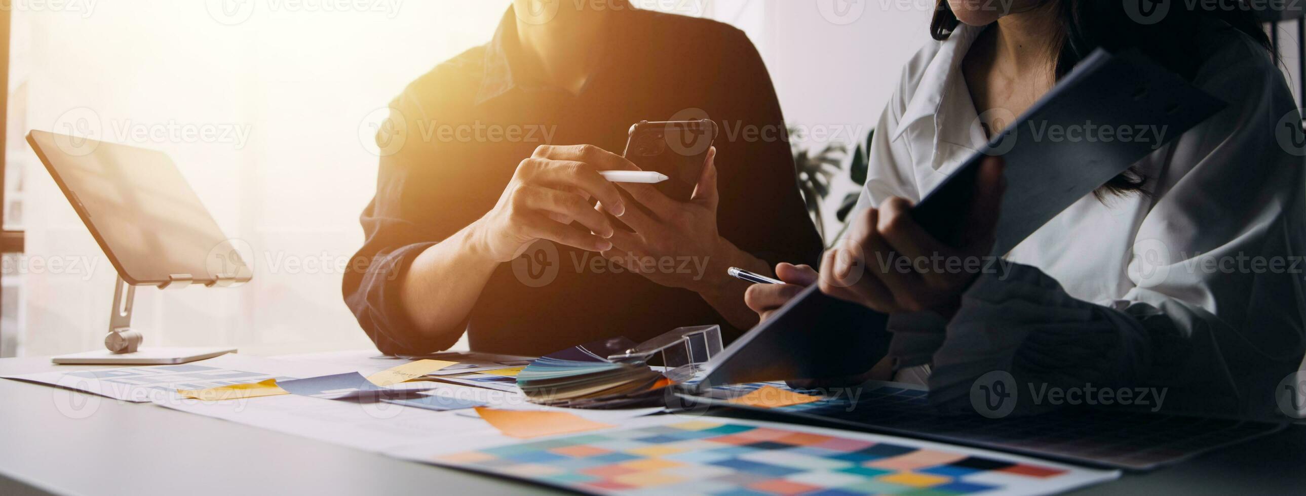 Close up ux developer and ui designer brainstorming about mobile app interface wireframe design on table with customer breif and color code at modern office.Creative digital development agency photo