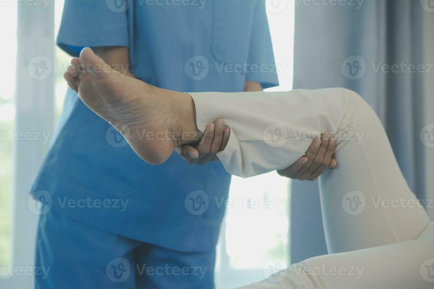 young asian physical therapist working with senior woman on walking with a walker photo