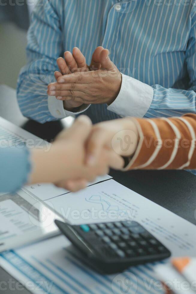 Financial analysts analyze business financial reports on a digital tablet planning investment project during a discussion at a meeting of corporate showing the results of their successful teamwork. photo