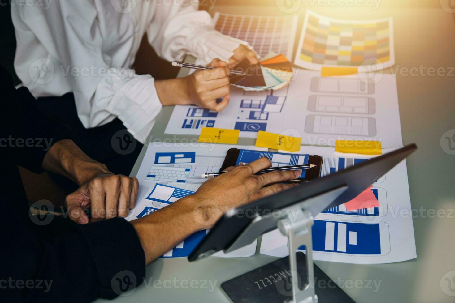 Close up ux developer and ui designer brainstorming about mobile app interface wireframe design on table with customer breif and color code at modern office.Creative digital development agency photo