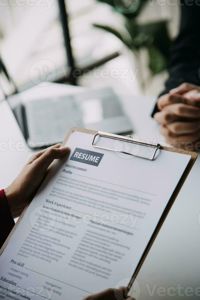 Businessman or job seeker review his resume on his desk before send to finding a new job with pen, necktie, glasses and digital tablet. photo