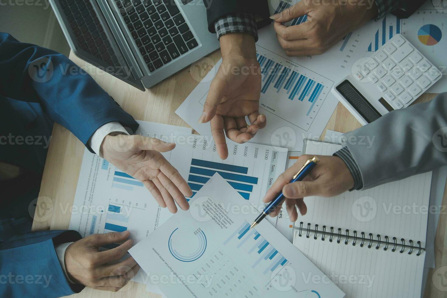 Group of confident business people point to graphs and charts to analyze market data, balance sheet, account, net profit to plan new sales strategies to increase production capacity. photo