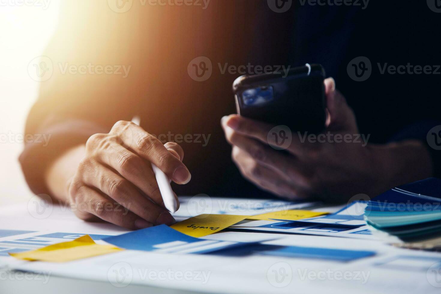 Close up ux developer and ui designer brainstorming about mobile app interface wireframe design on table with customer breif and color code at modern office.Creative digital development agency photo