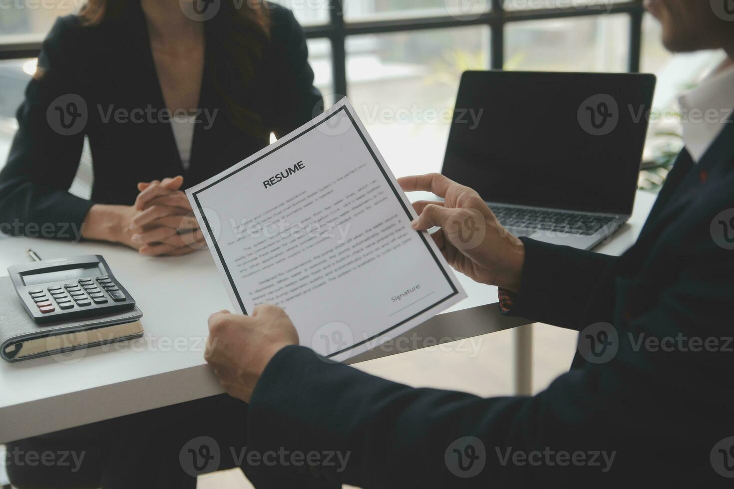 Close up view of job interview in office, focus on resume writing tips, employer reviewing good cv of prepared skilled applicant, recruiter considering application, hr manager making hiring decision photo