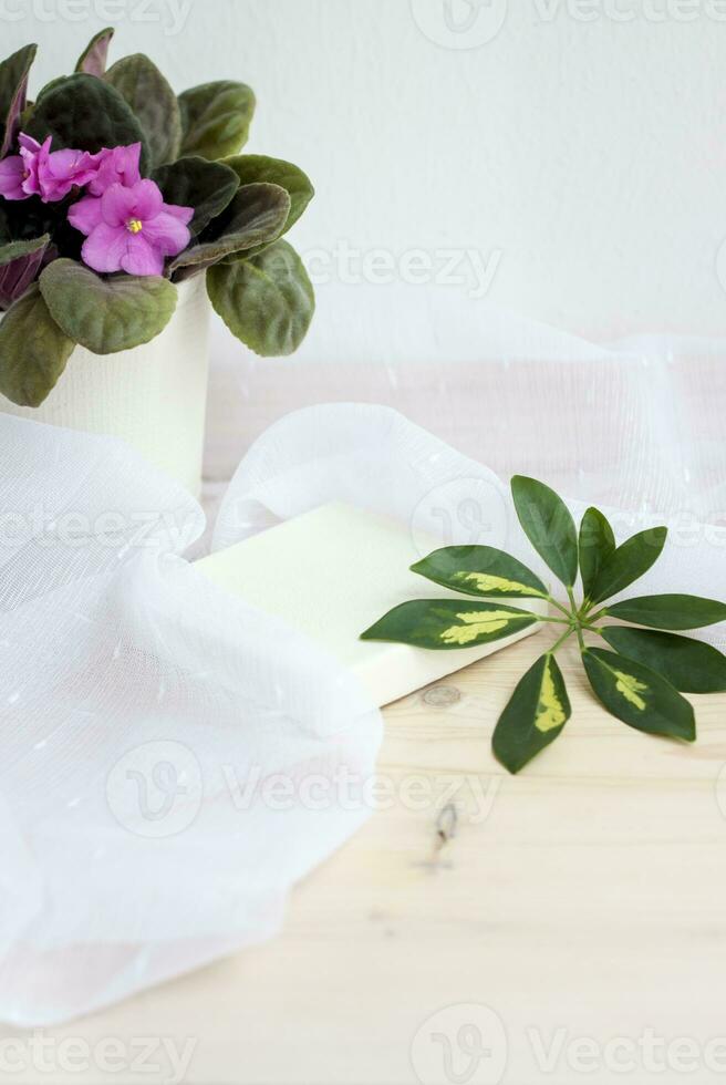 The square pedestal is covered with leather to support anything. Background for the design. Light composition of objects and colors. photo
