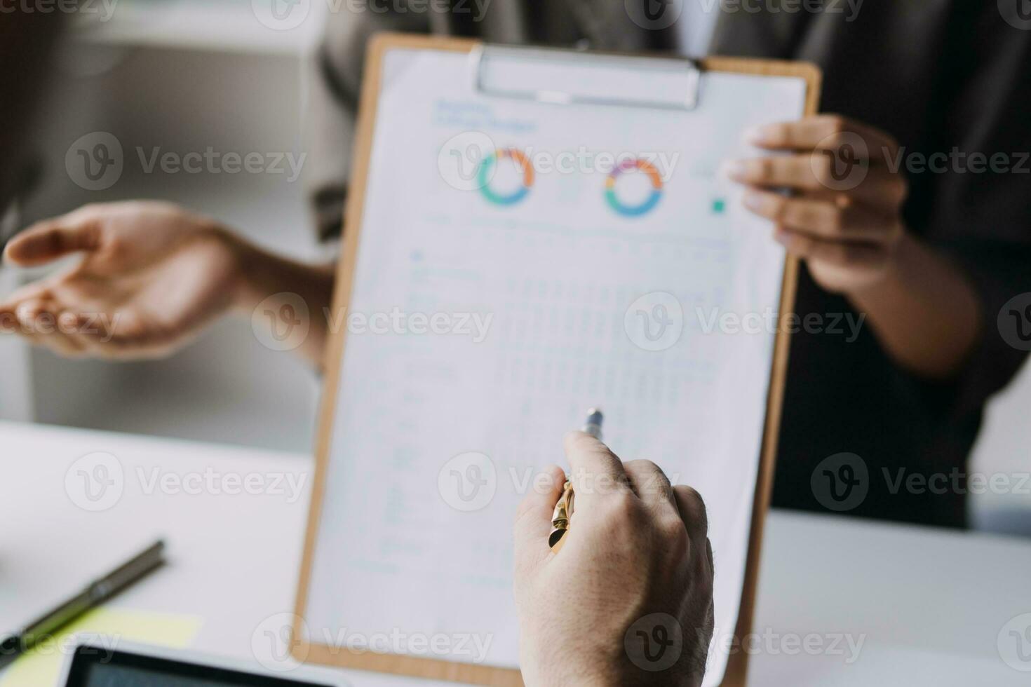 Financial analysts analyze business financial reports on a digital tablet planning investment project during a discussion at a meeting of corporate showing the results of their successful teamwork. photo