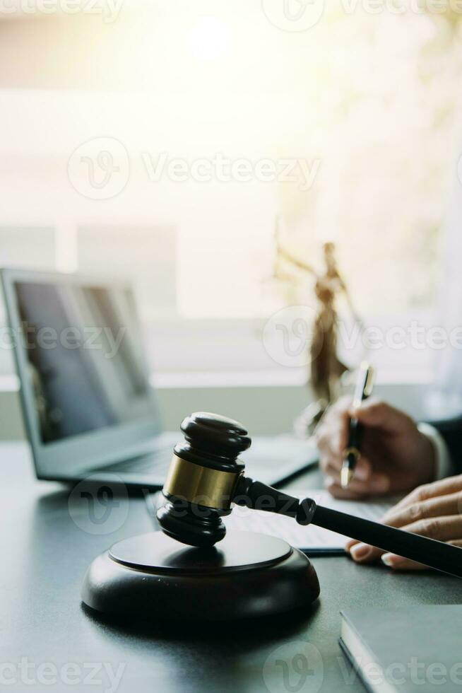 Business and lawyers discussing contract papers with brass scale on desk in office. Law, legal services, advice, justice and law concept picture with film grain effect photo