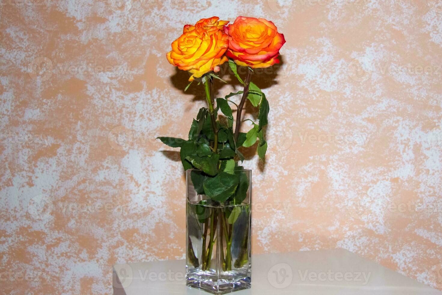 brillante rosas en un florero en el mesa. un ramo de flores de naranja rosas. foto