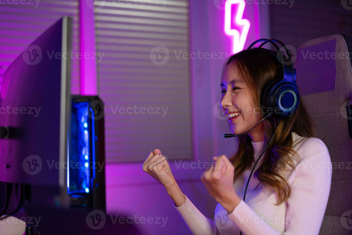 Asian gamer playing online video game winning excited on PC with lighting effect, broadcast streaming live at home. Gamer and E-Sport online gaming technology Championship tournament gamer concept. photo