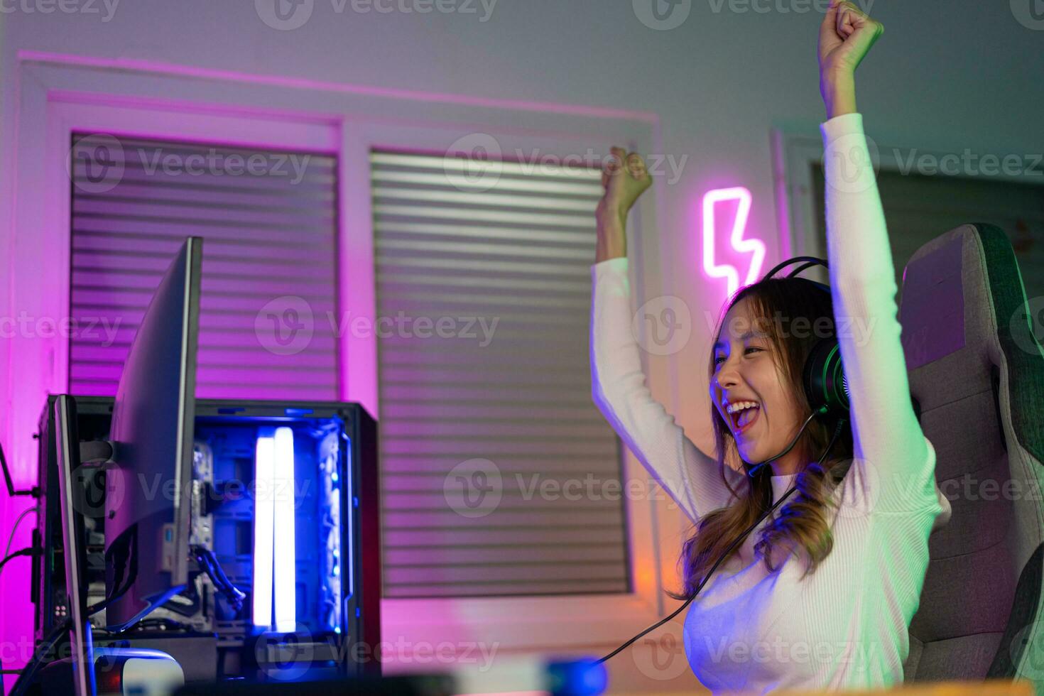 Asian gamer playing online video game winning excited on PC with lighting effect, broadcast streaming live at home. Gamer and E-Sport online gaming technology Championship tournament gamer concept. photo