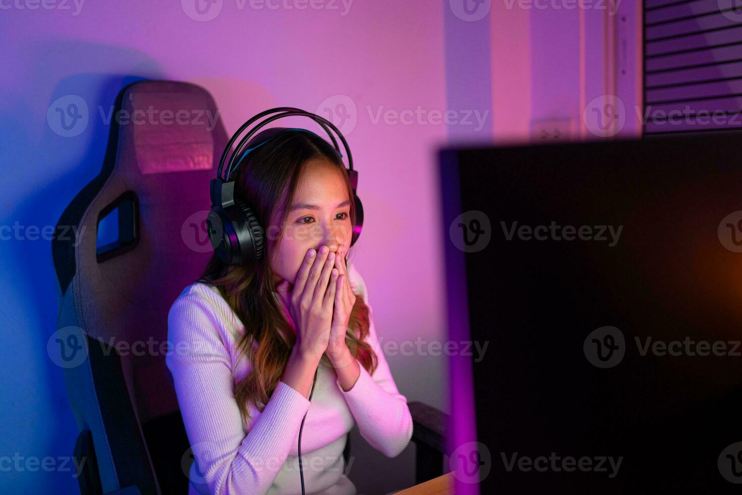 Asian gamer playing online video game winning excited on PC with lighting effect, broadcast streaming live at home. Gamer and E-Sport online gaming technology Championship tournament gamer concept. photo